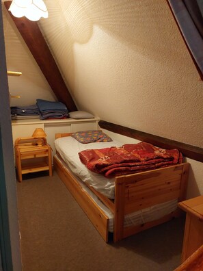 A small, cozy room with a single bed, a nightstand, and a lamp. - Large Apartment in the Hélios Residence (Barèges)