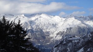 A mountainous landscape with snow-covered peaks and a forested area in the foreground. - Large apartment in the Hélios residence (Barèges)