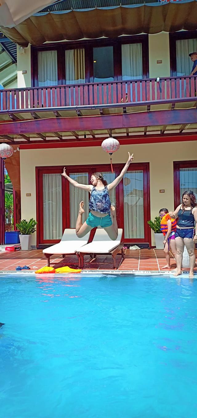 Ein Poolbereich mit Liegestühlen und einer Person, die eine Akrobatikvorführung zeigt.