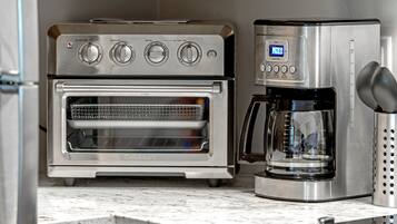 Una cocina con horno empotrado y cafetera.