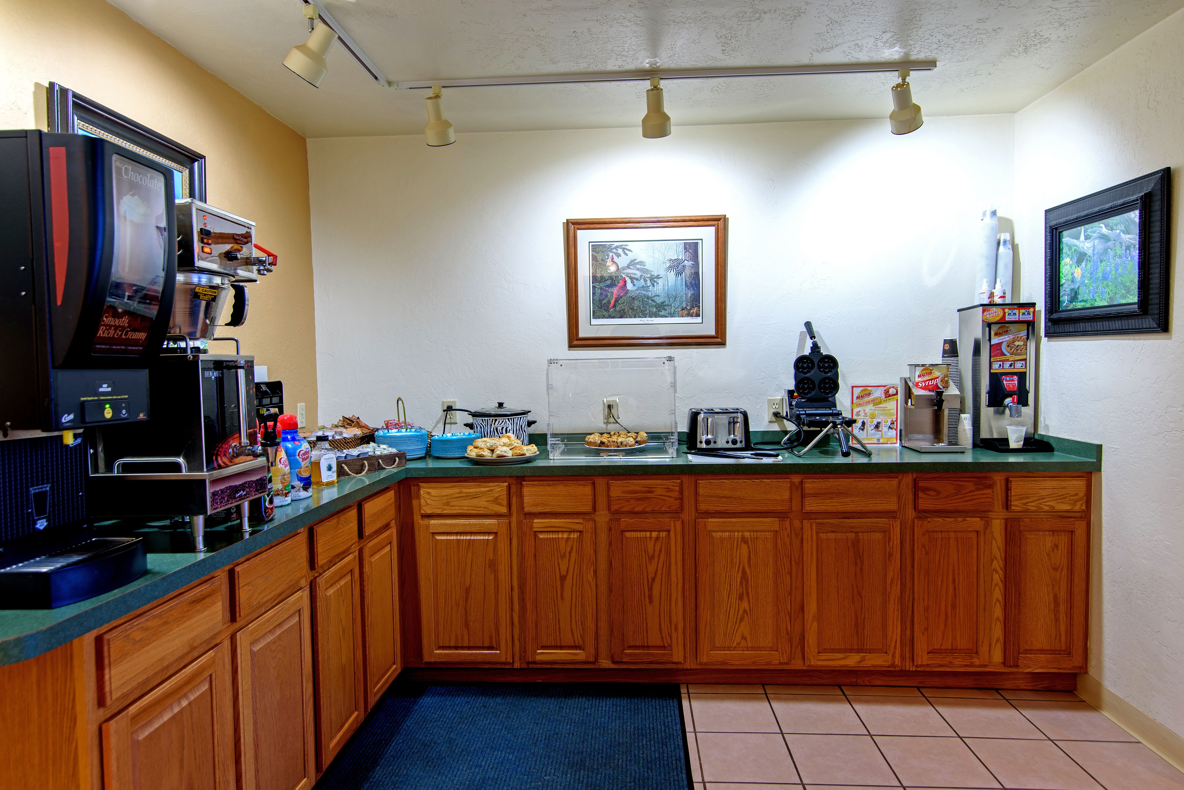 A kitchen with wooden cabinets, a coffee machine, a toaster, and a microwave.