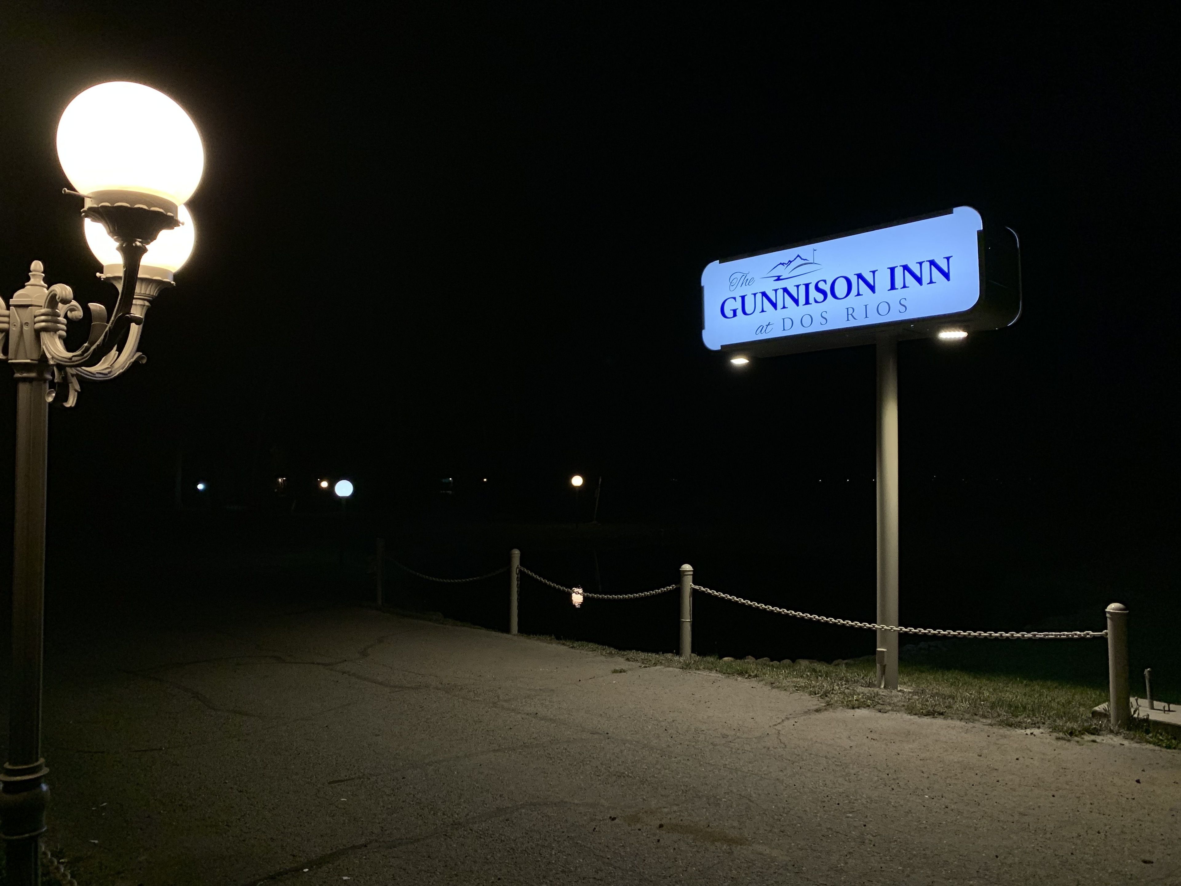 A nighttime view of the GUNNISON INN sign at DOS RIOS.