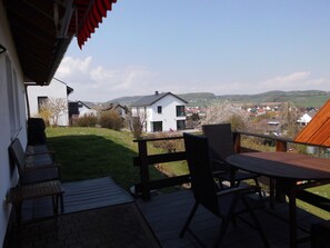 A terrace with a view of a residential area, including houses and hills. - 3 star apartment, quiet area, beautiful view, basic supply in the village (Diemelsee)