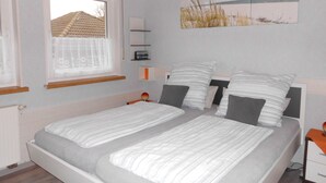 A bedroom with two beds, a window, a painting, and a bedside table. - 3 star apartment, quiet area, beautiful view, basic supply in the village (Diemelsee)