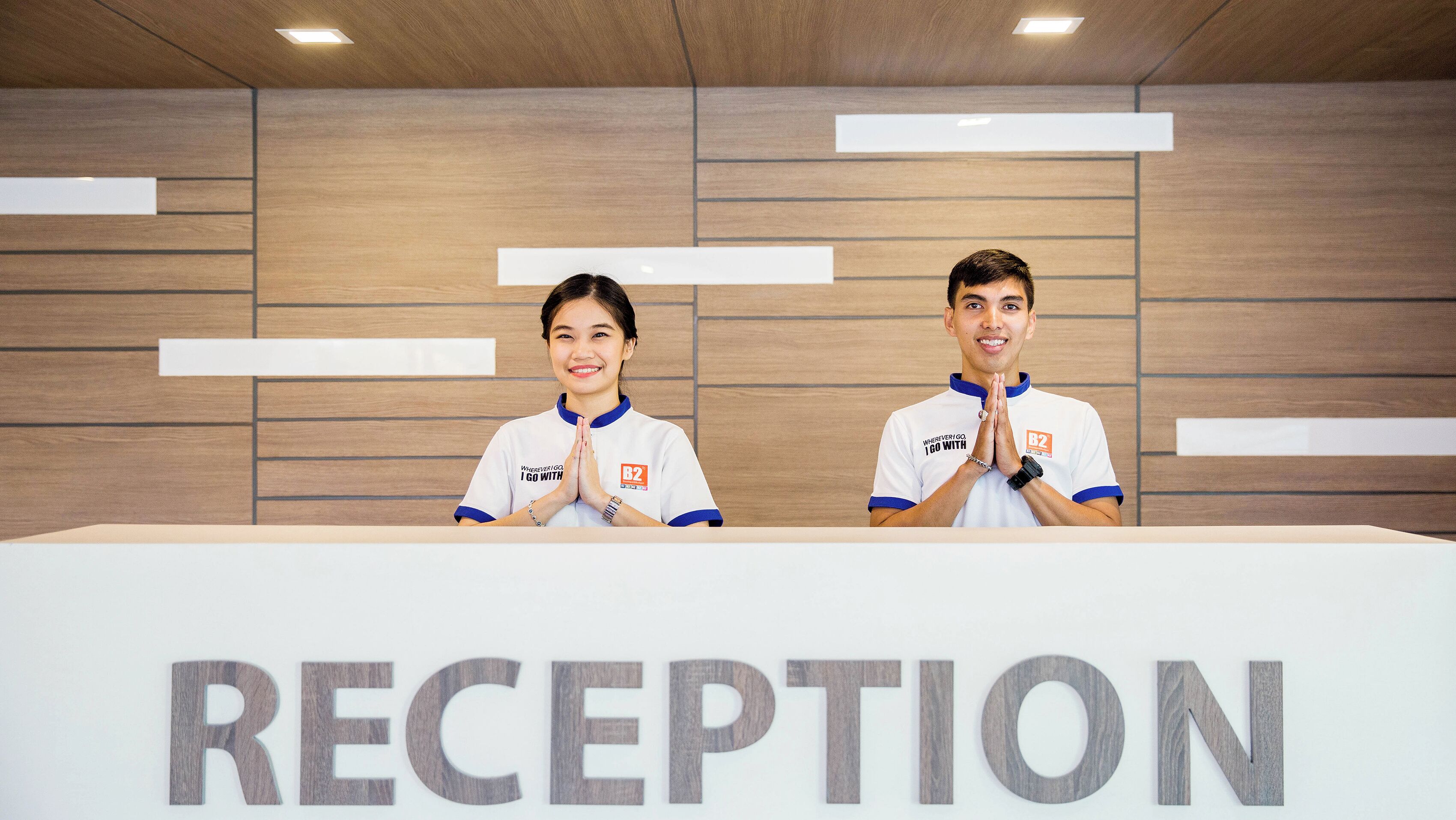 A reception area with a wooden wall and a reception desk labeled "RECEPTION".