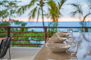 Enjoy a romantic meal for two on this oceanfront balcony with a stunning view of palm trees.