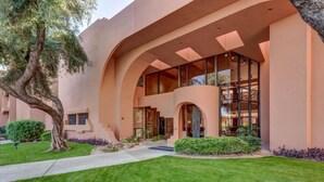 A modern building with a curved facade, large glass windows, and a well-maintained lawn. - Ace`s Cowboy Condo with a view (Phoenix)