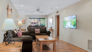 A living room with a sofa, coffee table, lamp, and TV. - Ace`s Cowboy Condo with a view (Phoenix)