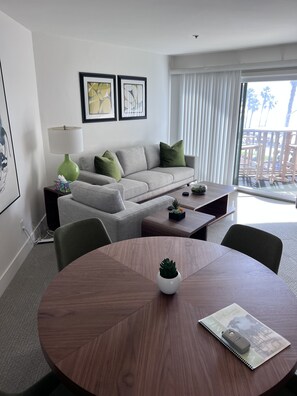 Relax in a stylish space with a comfortable sofa, dining table, and large window offering a view of the outdoor area.