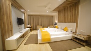 A modern hotel room with a large bed, bedside tables, a desk, and a TV. - Dhamma Grand Hotel Resort (Gaya)