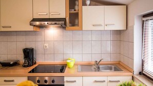 Una cocina moderna con horno integrado, cafetera y lavamanos.