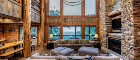 A spacious interior with a large fireplace, wooden beams, and a cozy seating area.