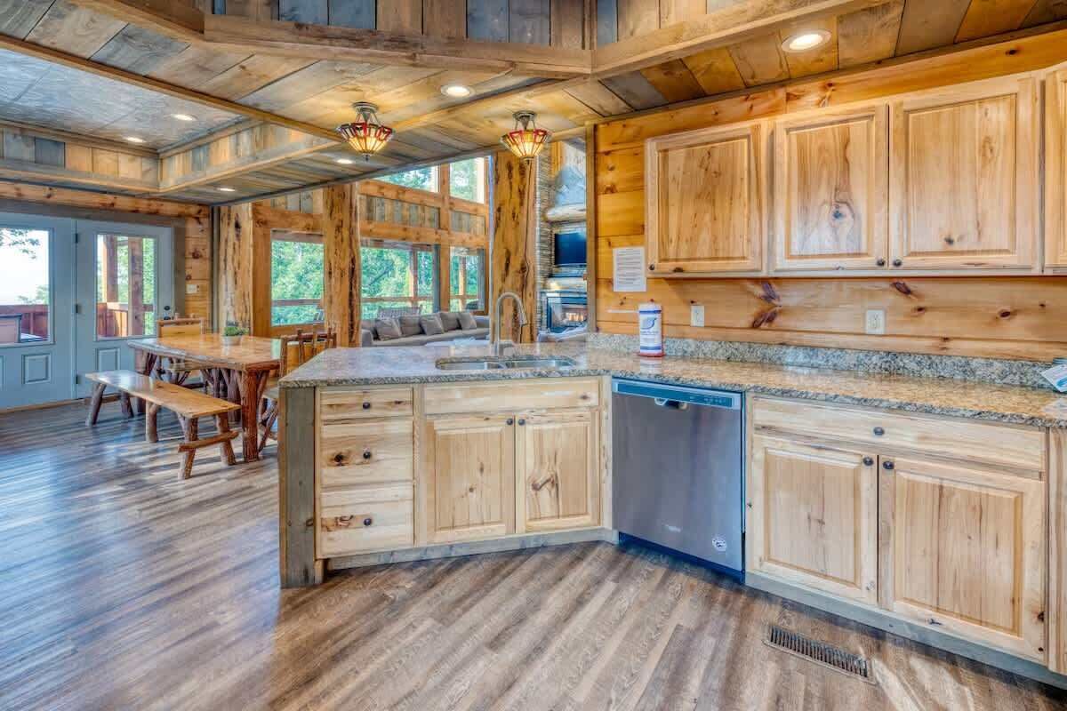 A spacious kitchen with wooden cabinets, a built-in dishwasher, and a large island with seating.