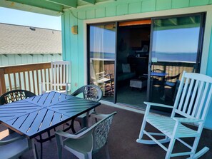 Enjoy al fresco dining on the patio, surrounded by a comfortable seating area and a view of the wooden deck.