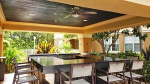 An outdoor kitchen area with a bar and seating. - Yacht Club at Aventura. Amazing Water View, Newly renovated (Aventura)