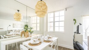 A bright dining area with white furniture, large windows, and a hanging rattan light fixture. - Yacht Club at Aventura. Amazing Water View, Newly renovated (Aventura)