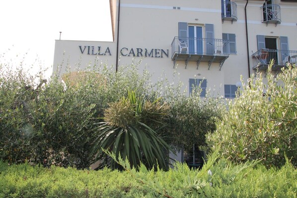 Villa Carmen, gebouw met balkons en een bord.