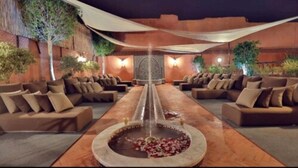 A spa area with a central fountain, seating arrangements, and decorative plants.