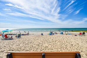 A beach with a sandy shore, umbrellas, and beach chairs. - Beach Getaway with Private Backyard! (Orleans)