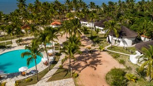 Un resort con piscina, palmeras y vistas a la playa.