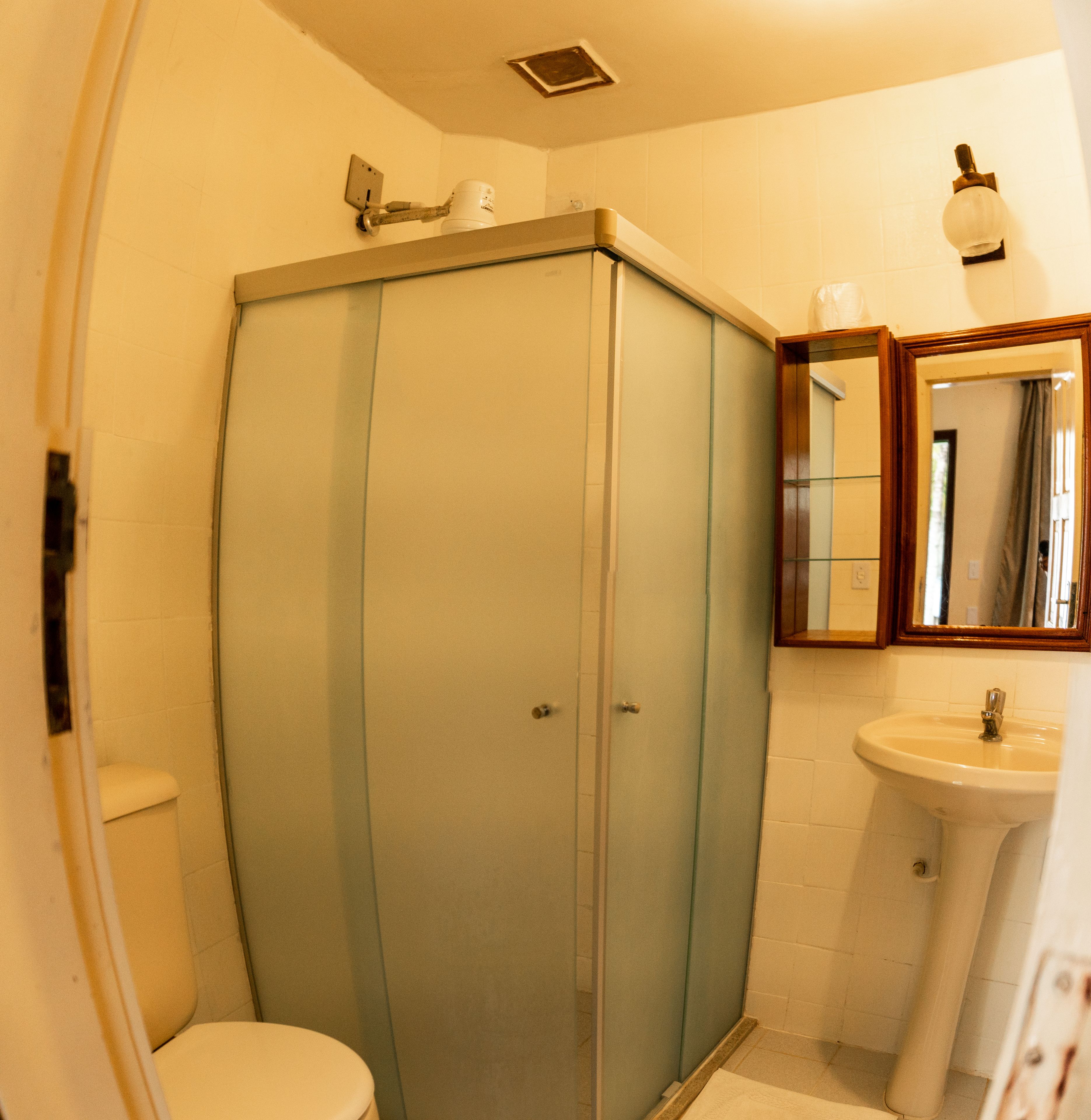 Une salle de bain avec une douche à parois de verre, des toilettes et un lavabo.