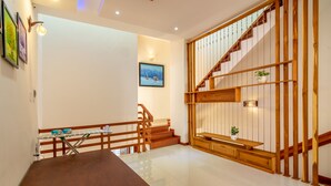 A spacious room with a wooden staircase, a dining table, and a view of the outdoors. - Pretty 4BR House@3MIN to the beach@ 3N Free pickup (Sơn Trà)