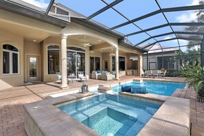 Piscina ao ar livre coberta com espreguiçadeiras e área de terraço.