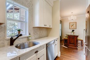 A kitchen with a sink, cabinets, and a window.