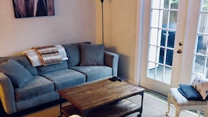 A living room with a sectional sofa, a coffee table, a chair, and a large window.