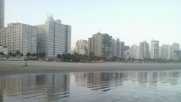 A beach with high-rise buildings in the background. - PRAIA GRANDE: Comfortable 3-bedroom beach house, well located near the sea. (Praia Grande)
