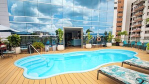 A rooftop pool with lounge chairs, potted plants, and a bar area. - Hotel Roseliere Bucaramanga (Floridablanca)