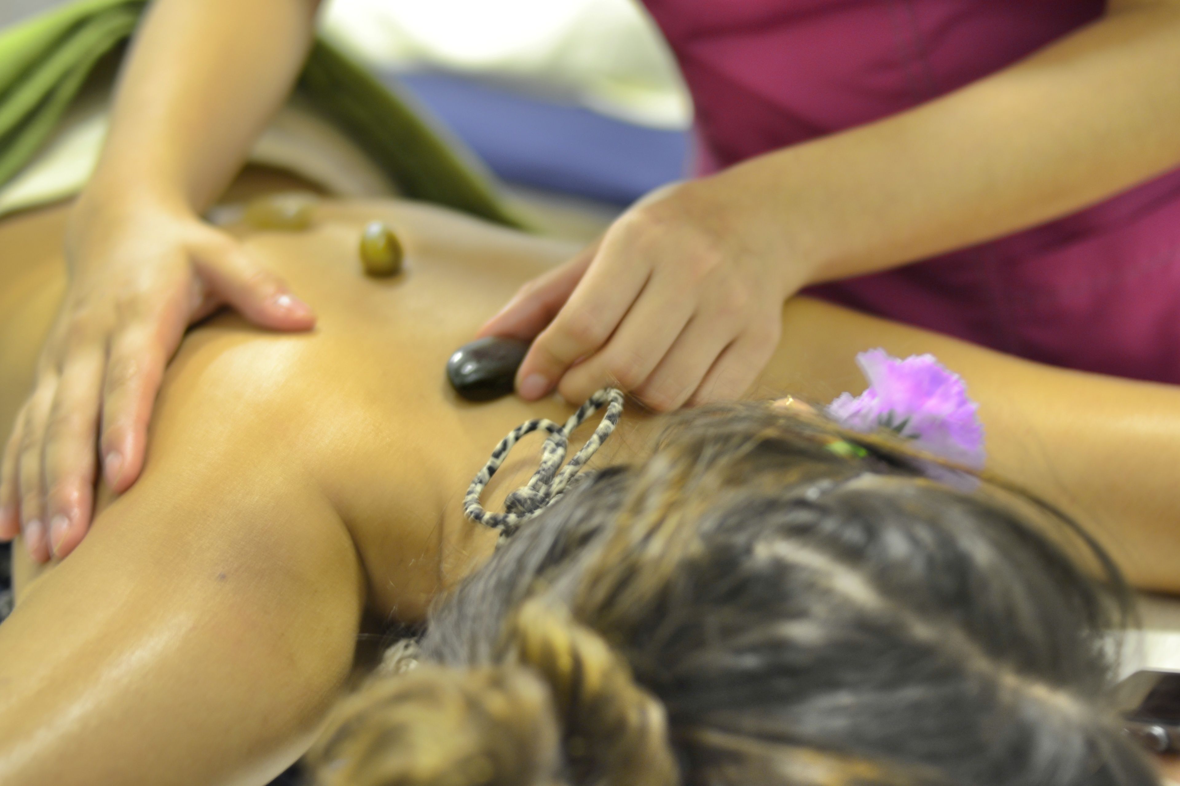 A massage therapy session with a person lying face down, receiving a back massage.