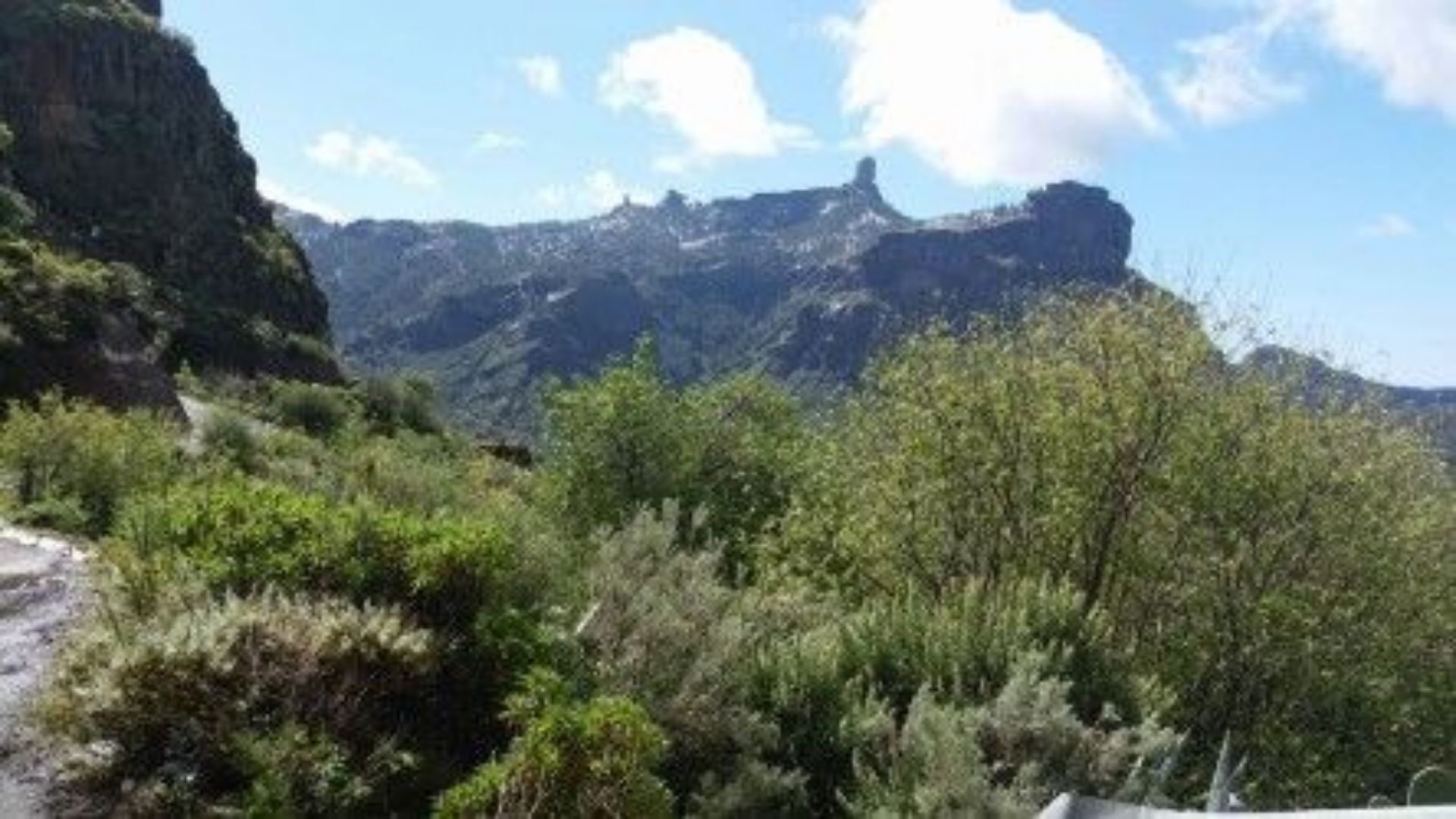 Paisagem montanhosa com vegetação densa e céu claro.
