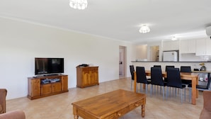 Een modern appartement met een woonkamer, eetgedeelte en keuken.