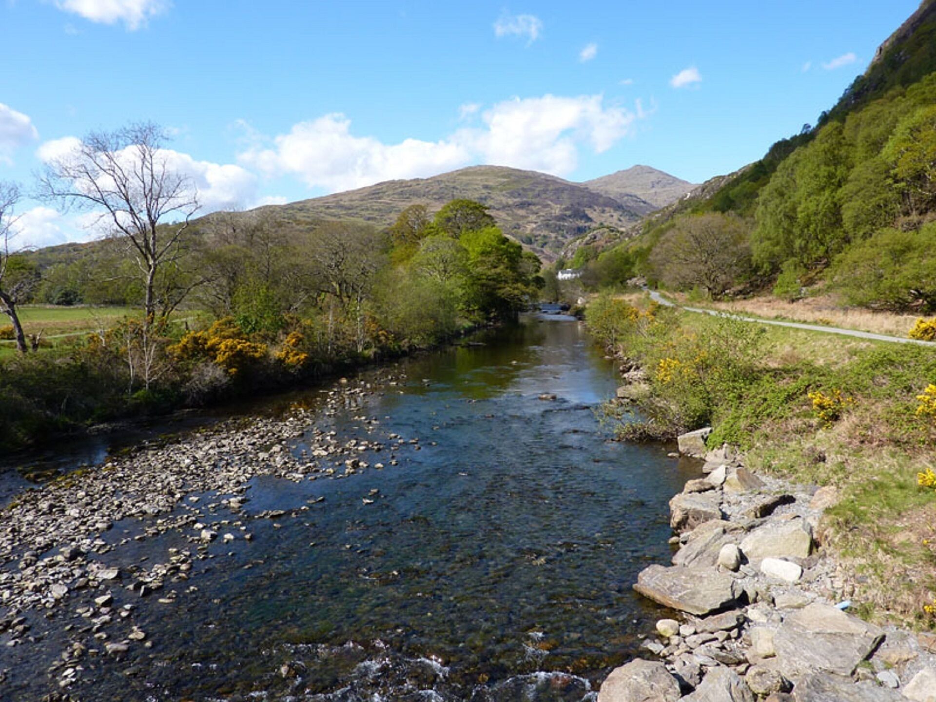 A river with rocky banks and a path alongside.