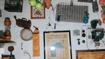 Een muur met diverse historische objecten, waaronder een krantenartikel in een lijst, een klok en een kaart.