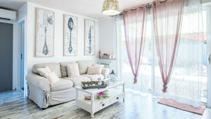 A living room with a sofa, a coffee table, and artwork on the wall. - VILLA ROMANCE: relaxation, heated pool, private spa, bikes, and Wi-Fi (Biscarrosse)