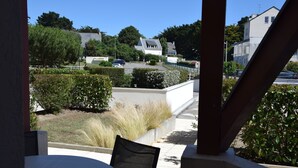 A patio area with a table and chairs, surrounded by well-maintained hedges and plants. - T2 on the ground floor overlooking the port of Crouesty (Arzon)