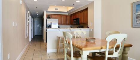 A spacious kitchen with wooden cabinets, a central island, and a dining area with a wooden table and chairs.