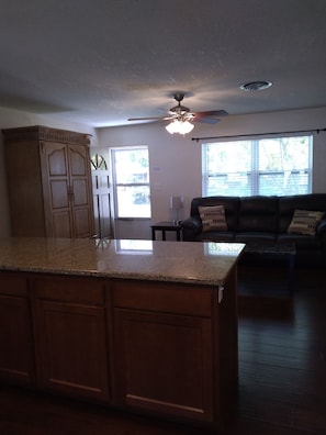 Relax in this inviting living area with a kitchen island and comfortable sofa.