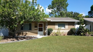Welcome to a charming home with a beautifully manicured lawn and lush surroundings.