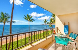 A balcony with a view of the ocean, palm trees, and a table with chairs. - 🤙 Sept-Oct-Nov SPECIALS PLUS VRBO discounts 🏝️ at the LIVE ALOHA SUITE (Kihei)
