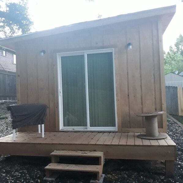 A wooden deck with a sliding glass door, a covered table, and a small bench. - The In-town spot near Beltline & major retail (Atlanta)