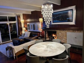 Una sala de estar acogedora con chimenea, un ventanal grande y un rincón de estar confortable.