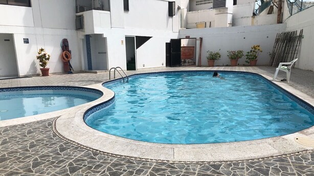 A swimming pool with a stone-tiled deck, a smaller adjacent pool, and potted plants. - TOP LOCATION SAN ANDRES (San Andrés)
