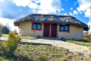 Casa con techo de paja y un sendero de piedra que lleva a la entrada.