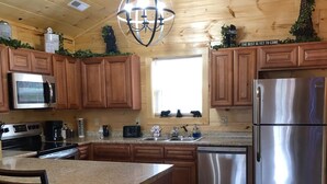 Una cocina moderna con armarios de madera, electrodomésticos de acero inoxidable y una isla central.