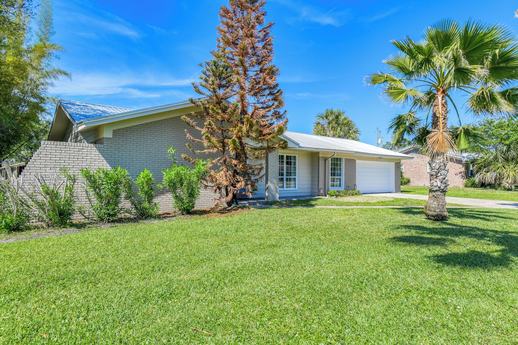 A single-story house with a brick exterior, a garage, and a well-maintained lawn.