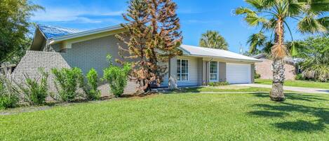 A single-story house with a brick exterior, a garage, and a well-maintained lawn.