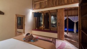 A cozy room with a bed, a window with curtains, and a wooden ceiling. - Dolcemare Resort (Gili Air)